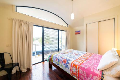 a bedroom with a bed and a large window at Halls Gap Townhouse Escape in Halls Gap