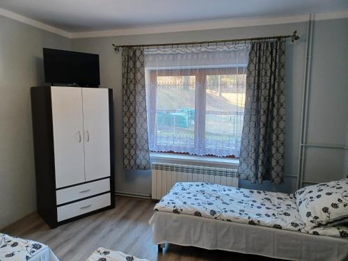 a bedroom with two beds and a dresser and a window at Agroturystyka Leśna Ostoja Borek in Golczowice