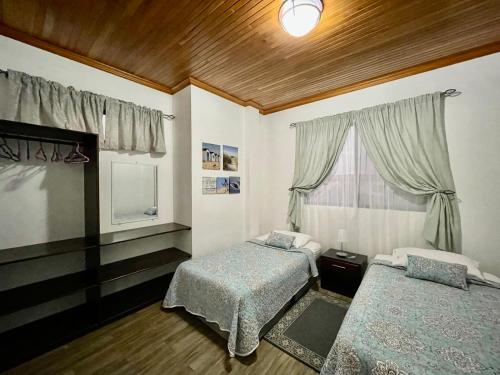 a bedroom with two beds and a window at Apartahotel Casa Soleil in Puerto Villamil