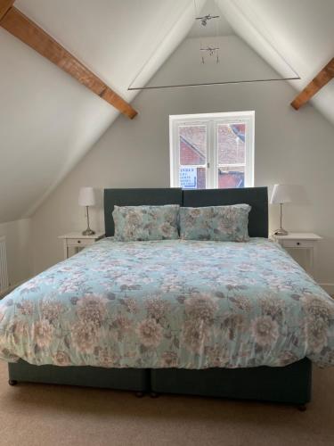 a bedroom with a bed with a floral bedspread at Roundhill New Forest in Fordingbridge