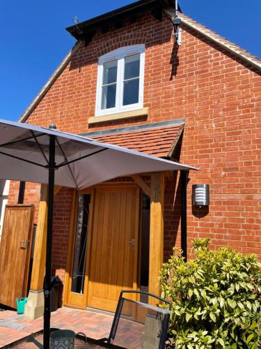 a house with an umbrella in front of it at Roundhill New Forest in Fordingbridge