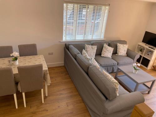 a living room with a couch and a table at Roundhill New Forest in Fordingbridge