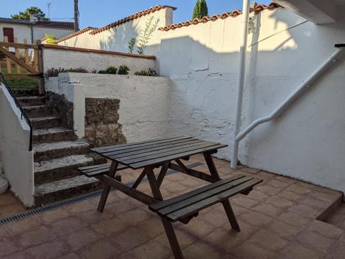 a wooden picnic table sitting on a patio with stairs at Gîte proche canal La Conserverie in Buzet-sur-Baïse