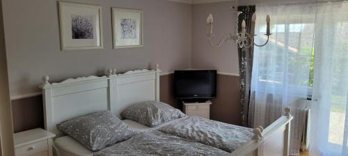 een slaapkamer met een bed, een tv en een raam bij Stilvolles Apartment "Romantic" in Neukirchen vorm Wald