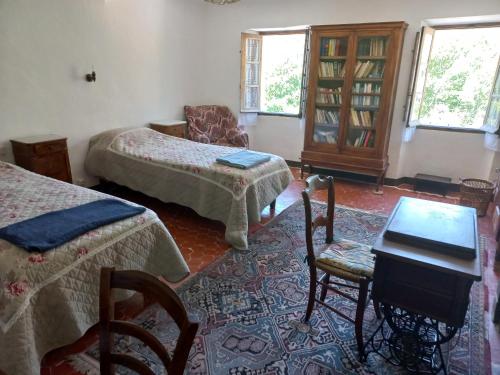 um quarto com duas camas e uma mesa e cadeiras em Maison de caractère em La Bastide