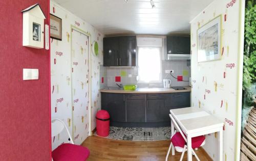 a small kitchen with red and white walls at Gîte Les Bignones in Freneuse