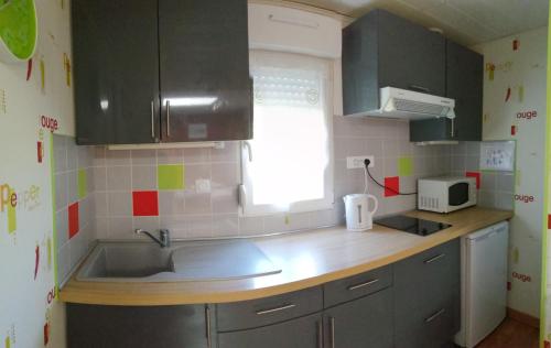 une cuisine avec un évier et un plan de travail dans l'établissement Gîte Les Bignones, à Freneuse