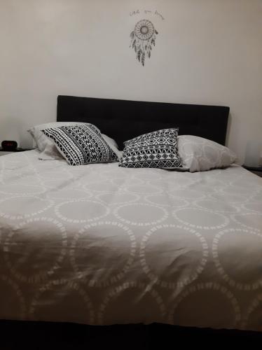 a bed with four pillows on top of it at Le Logis des Templiers appartement climatisé in Régusse