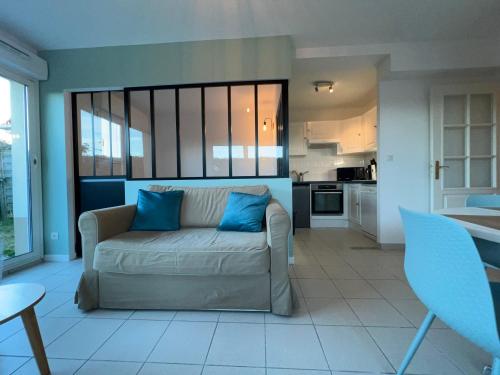 un salon avec un canapé et une cuisine dans l'établissement Appartement plage restaurant et parking privatif, à Wimereux