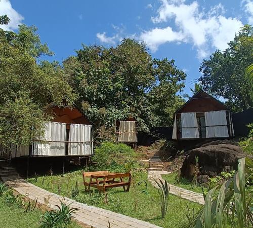 a house with a bench and a table in a yard at Nada Brahma Patnem Beach in Patnem