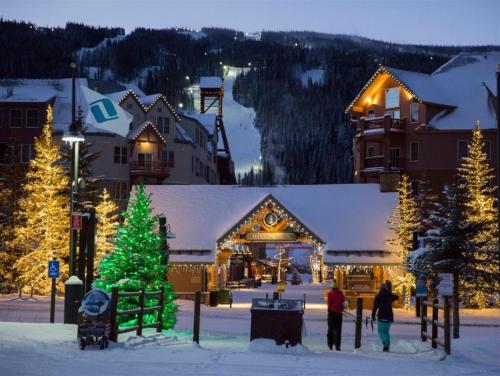 a group of people standing in the snow in front of a lodge at Charming Condo Nestled In The East Keystone Resort Neighborhood, Shuttle To Ski Slopes, Outdoor Pool And Hot Tub in Dillon