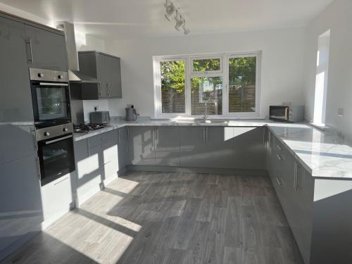 a large kitchen with white counters and a large island at House - Sleeps 14 onsite parking & pets allowed in Poole