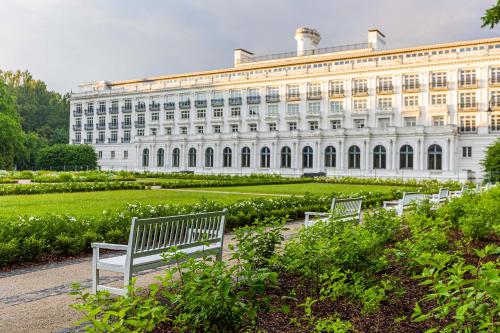 a large white building with benches in front of it at Schneider hause in Jūrmala