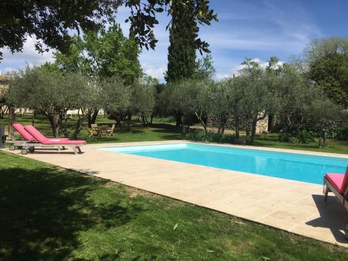 einen Pool in einem Garten mit Bäumen in der Unterkunft la maison des Olivettes in Uzès