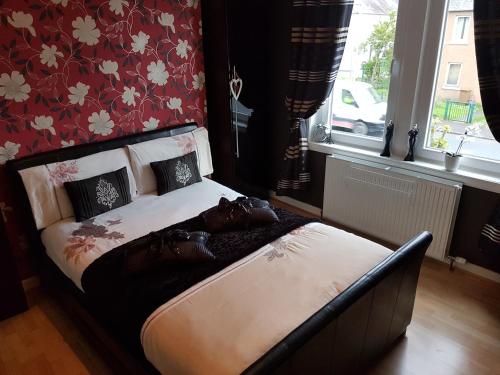 a bed sitting in a room with a window at Spacious 2 double bedrooms house for a relaxing stay. in Inverness