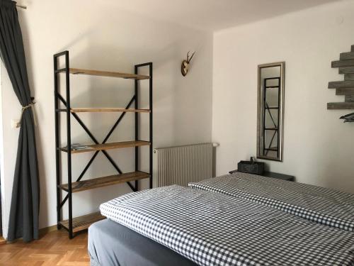 um quarto com uma cama e uma estante de livros em Appartement Brettljause Ferienhaus Fuenf Sinne em Döbriach