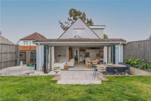 a backyard with a patio and a house at Beautiful 4 Double Bedroom House in Poole with Hot tub, near Sandbanks in Poole