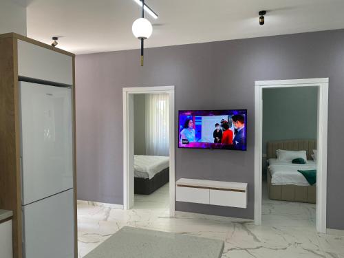 ゴニオにあるOrAnge villaの壁にテレビとベッドが備わる客室です。