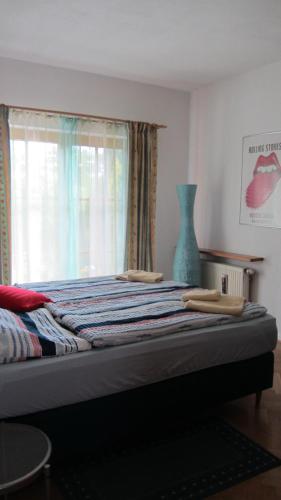 a bed in a room with a window and a vase at Haus Renia in Markdorf