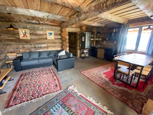 a living room with a couch and a table at Mountain Cricket Chalets and Apartments Gudauri in Gudauri