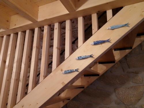 four fish are lined up on a wooden beam at Casa da Florbela in Fafe