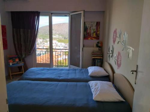 2 camas en un dormitorio con balcón en Panoramic View of Drepano (Nafplio), en Dhrepanon