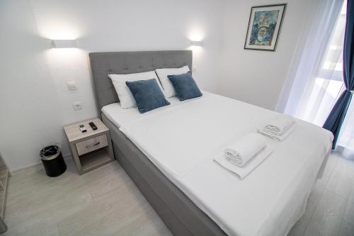 Un dormitorio con una gran cama blanca con almohadas azules. en Villa Sonata, en Mostar