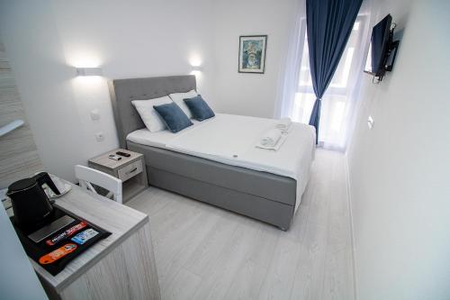 Dormitorio pequeño con cama con almohadas azules en Villa Sonata, en Mostar