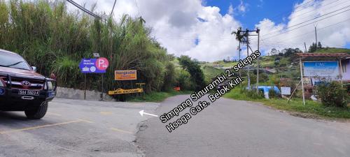 a sign on the side of a road with a car at Sinurambi 2 in Kundasang