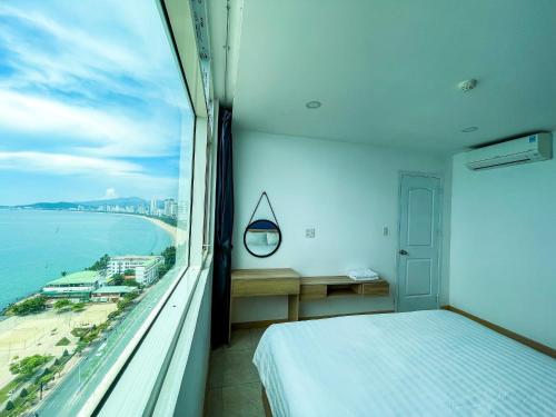 a bedroom with a bed and a view of the ocean at NHA TRANG COMFORTZONE APARTMENT in Nha Trang