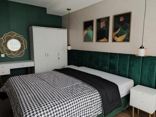 um quarto com uma cama com paredes verdes em Apartemen Strategis Yogyakarta em Seturan