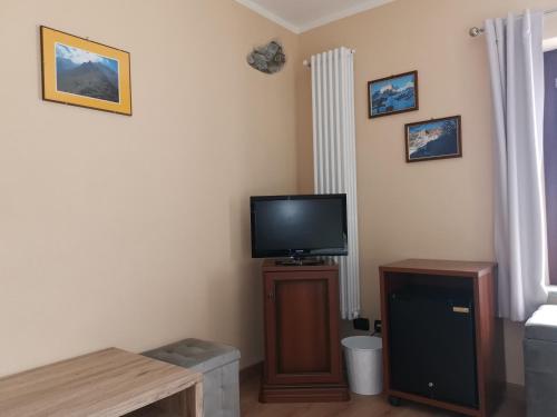 uma sala de estar com uma televisão num suporte de madeira em Al Drit em Verrès