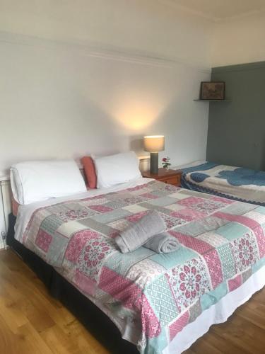 a bedroom with a bed with a quilt on it at City centre rooms Abercorn road ltd free parking free WiFi in Derry Londonderry