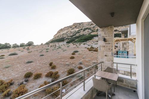 a balcony with a table and chairs and a hill at Luxury Villas Ammos in Style in Matala