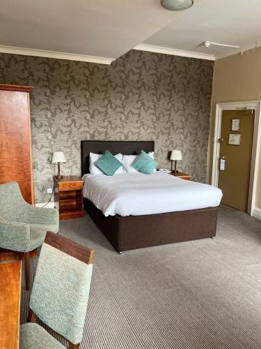 a hotel room with a bed and a chair at Manor Hotel by Greene King Inns in Yeovil