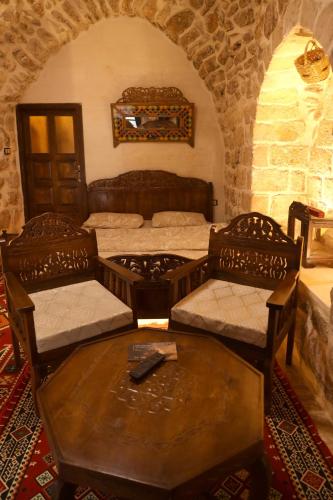 a room with two beds and a table and chairs at BEYT NAHRAYN KONAK in Mardin
