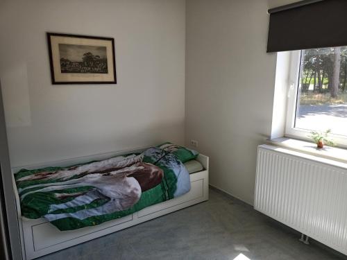 a bedroom with a bed sitting next to a window at Vakantiehuis Mastdreef in Breda