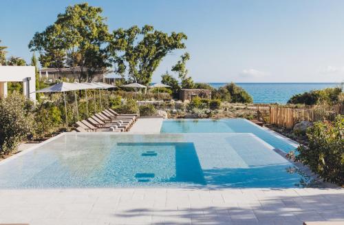 a swimming pool with the ocean in the background at Casa Paradisu in LʼÎle-Rousse