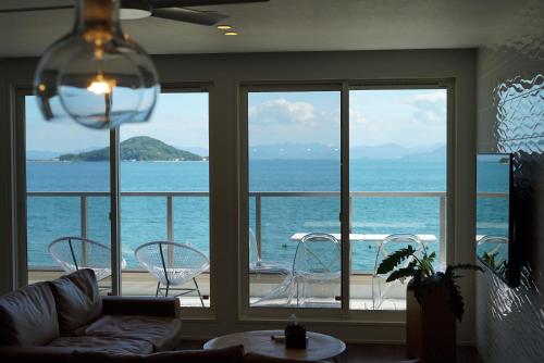 a living room with a view of the ocean at SETOUCHI SUP RESORT - Ao - in Shodoshima