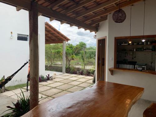 a kitchen with a wooden table and a patio at Casa Corumbau temporada Recanto Ipê-Amarelo a 400m da praia in Corumbau