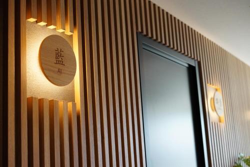 a door in a room with a clock on the wall at SETOUCHI SUP RESORT - Ao - in Shodoshima
