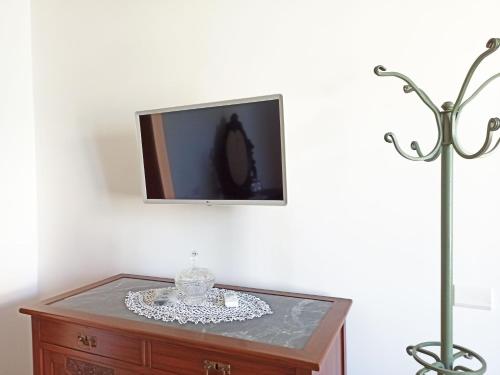 a tv sitting on top of a wooden dresser with a glass plate at Emerald's Resort - Filomena in Conca dei Marini