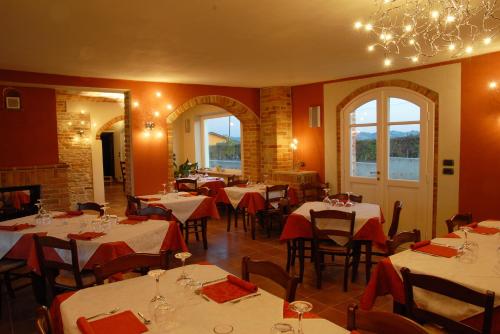 a restaurant with tables and chairs with red walls and windows at AGRITURISMO CINQUE CAMINI in San Marzano Oliveto