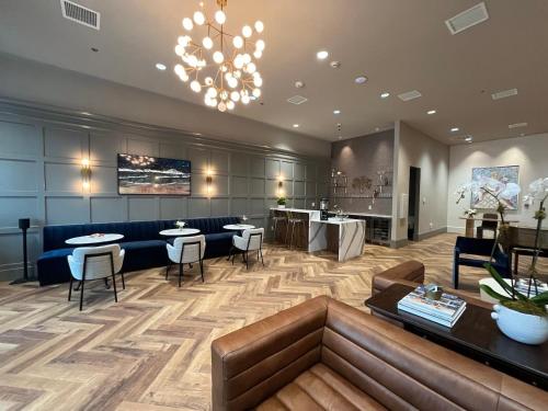 a lobby with tables and chairs and a chandelier at The Thomas Hotel - Garden Suite ADA - 02 in Tyler