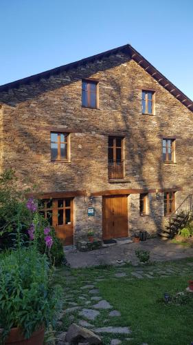 a large stone house with wooden doors and windows at Casa Rural Norita - Adults only in Lourenzá