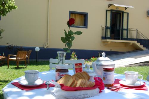 a picnic table with bread and coffee and cups on it at Albicocche House in Giarre
