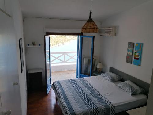 a bedroom with a bed and a door to a patio at MAMMA MIA On THE BEACH in Pefkali