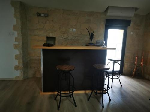a kitchen with three bar stools and a counter at APPARTEMENT COSY LIBOURNE in Libourne