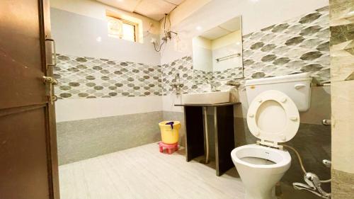 a bathroom with a toilet and a sink at Hotel Prabhat Palace in Kota