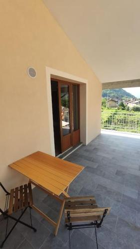 a wooden table and a bench in a room at La casa dei nonni 3,0 in Carema